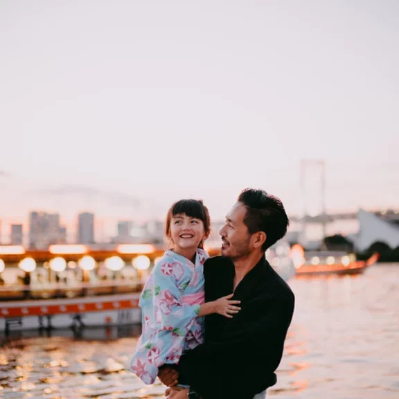 Japanese father and preschool daughter wearing kimono on boat, Tokyo - Getty Images